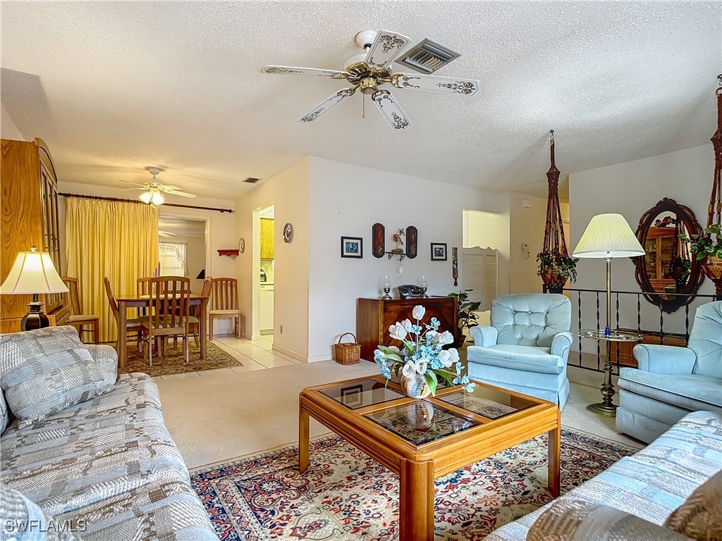 19040 Geranium Road Fort Myers, FL 33967 - Photo 9 of 42 a living room with furniture a dining table and a chandelier