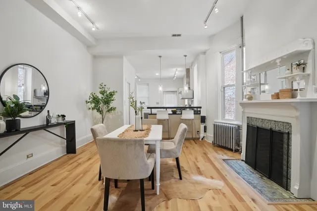a dining room with furniture potted plants and wooden floor