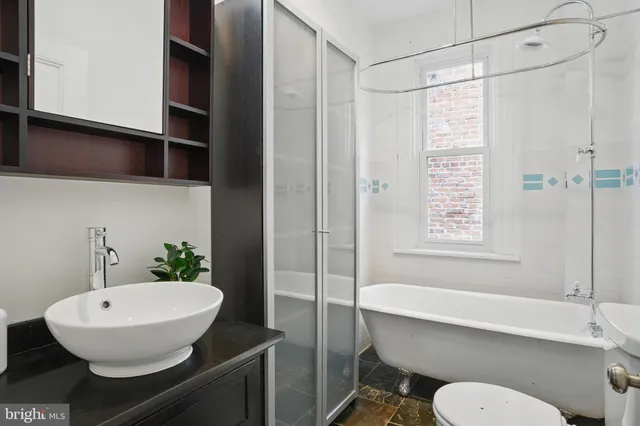 a bathroom with a sink toilet a mirror and shower