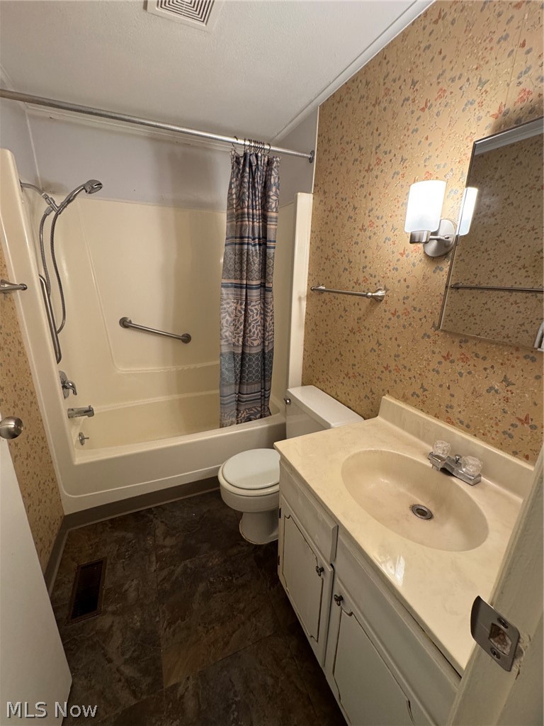 7294 Fox Mill Road, Unit 19D Mentor, OH 44060 - Photo 21 of 27 Bathroom featuring a full tub/shower combination with grab bars, a white vanity with an integrated sink, a wall-mounted light fixture, and patterned wall covering