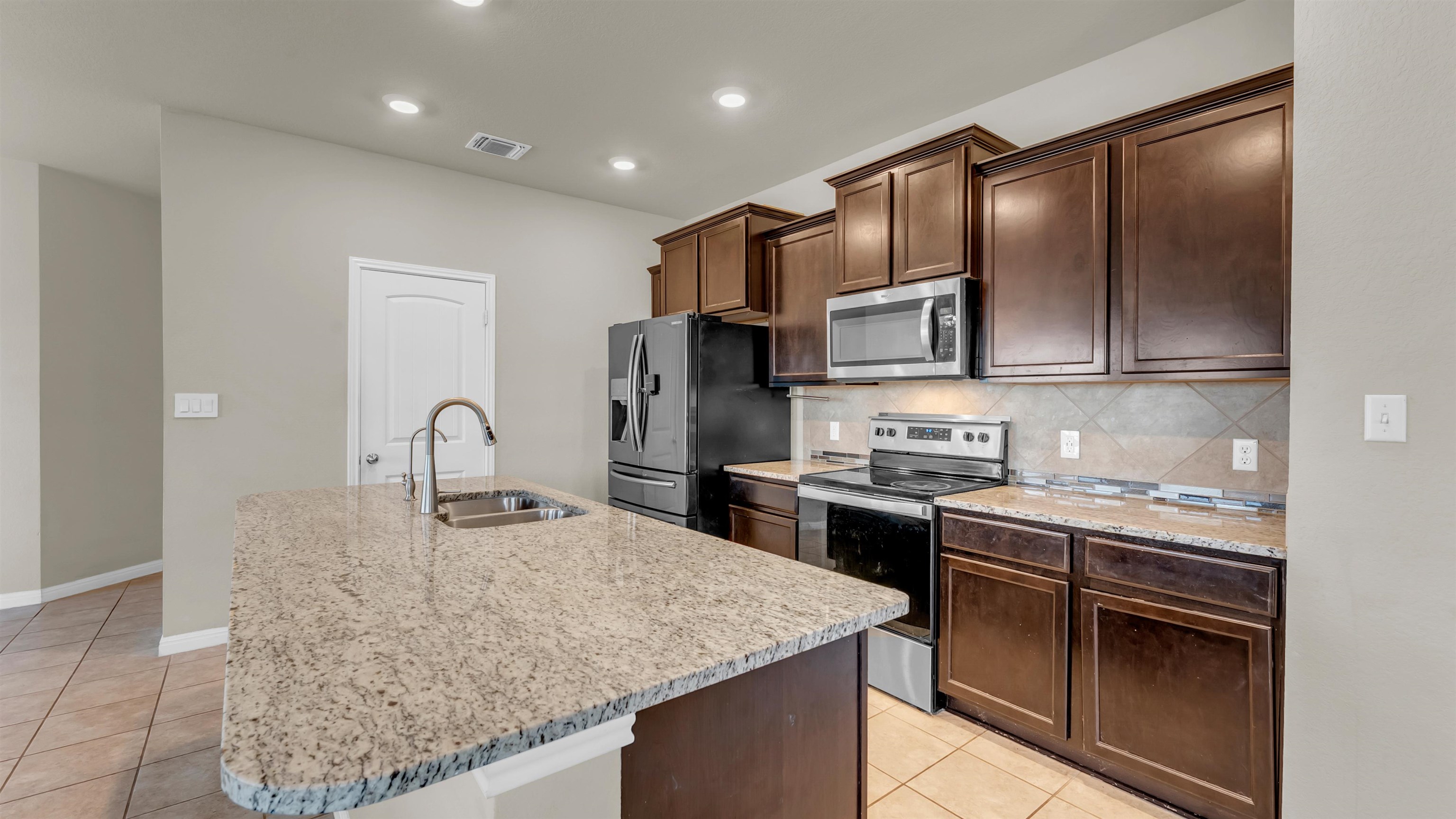 100 Pepper Mill Loop Burnet, TX 78611 - Photo 12 of 27 Kitchen featuring large kitchen island with granite countertops.