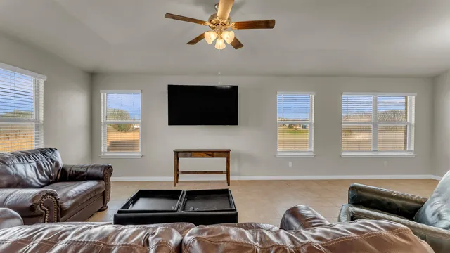 a living room with furniture ceiling fan and a window