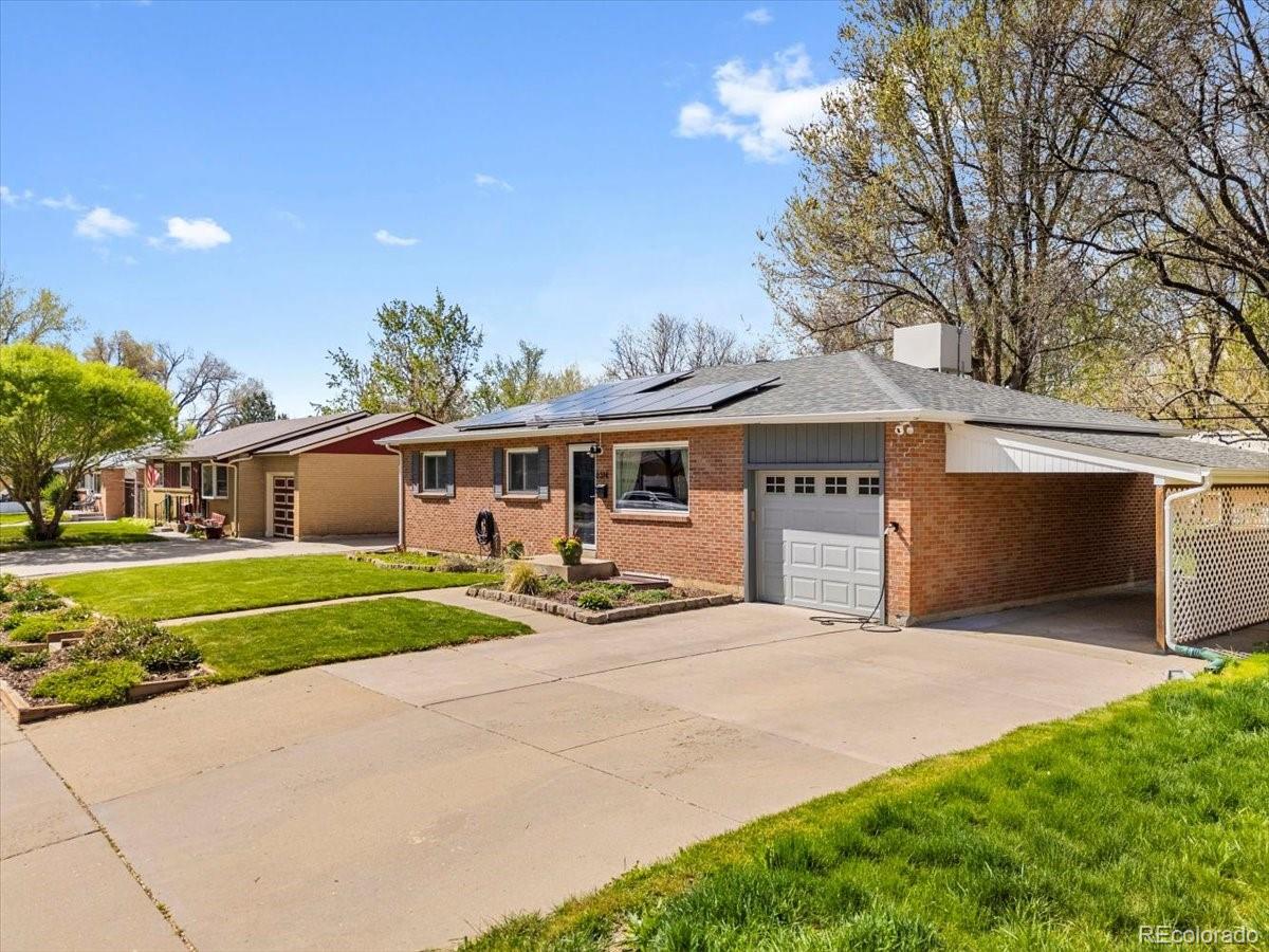 a front view of house with yard and trees in the background