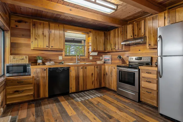 a kitchen with stainless steel appliances a stove a sink and a refrigerator