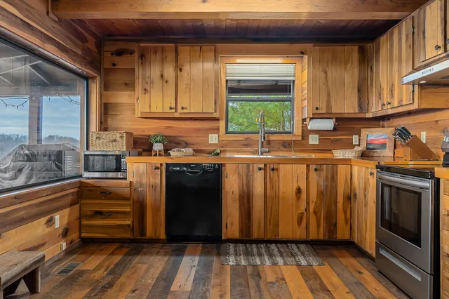 a kitchen with kitchen island granite countertop a sink cabinets and stainless steel appliances