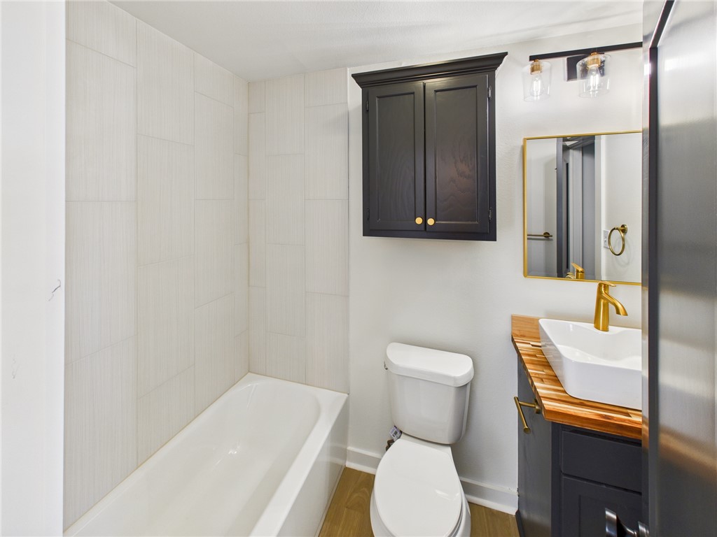 309 Mobile Avenue, Unit 6 Bryan, TX 77801 - Photo 12 of 12 Bathroom featuring vanity, wood finished floors, and shower / bath combination