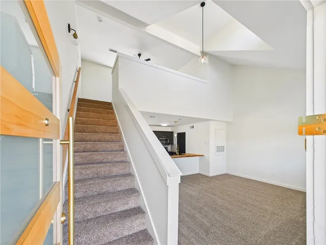 a view of staircase with white walls and railing