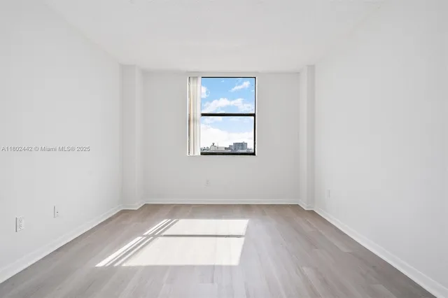 a view of an empty room with wooden floor