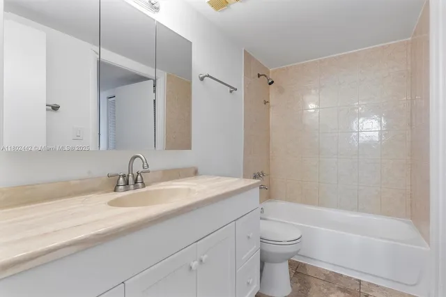 a bathroom with a granite countertop sink a toilet and a bathtub