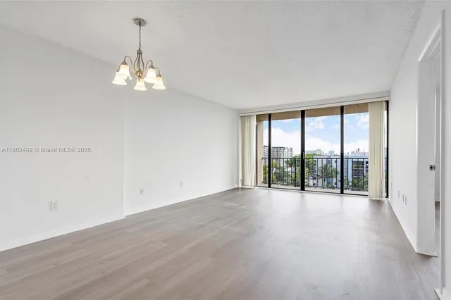 an empty room with wooden floor and door