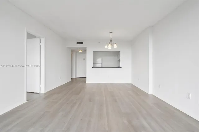 a view of empty room with wooden floor and sink