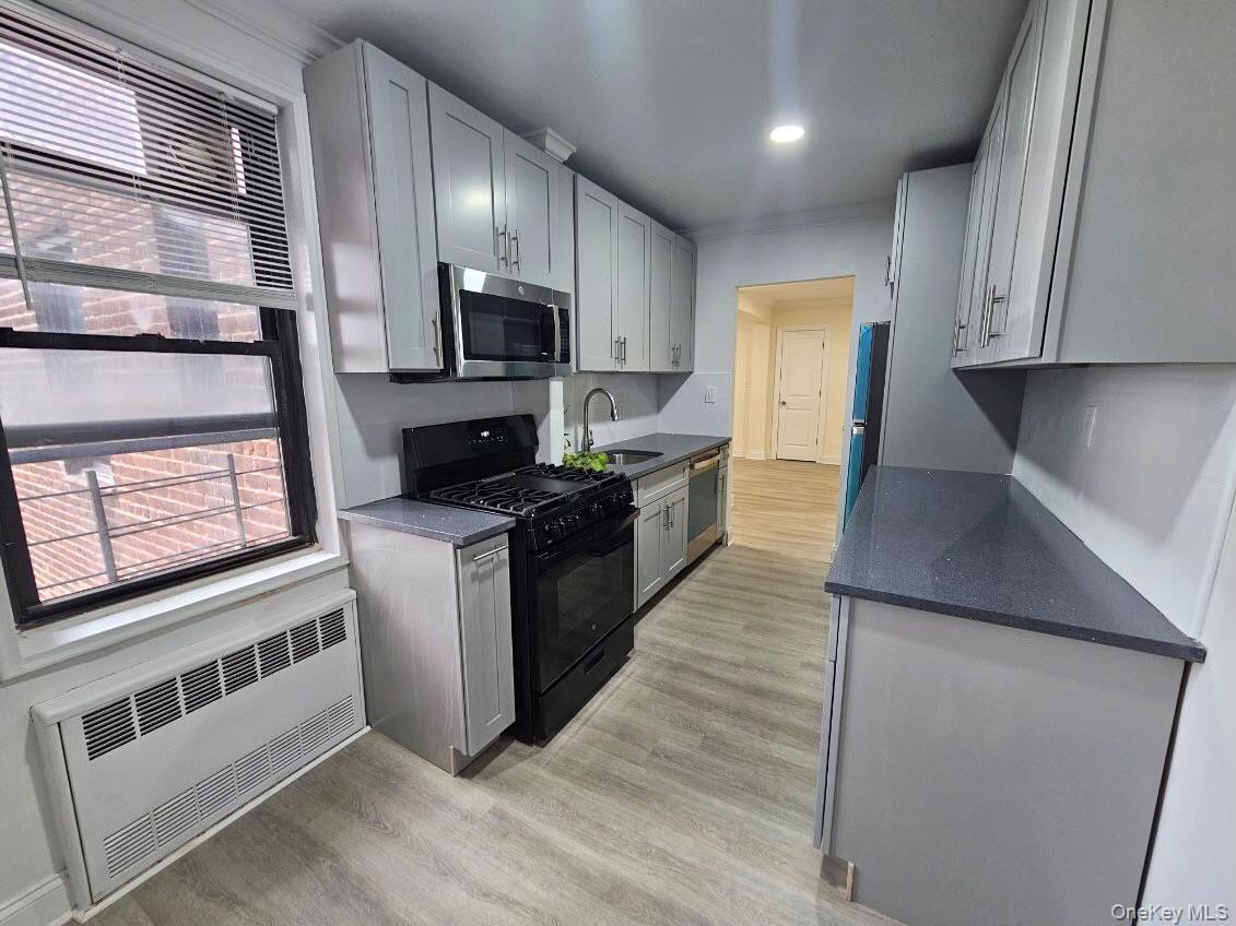 a kitchen with stainless steel appliances granite countertop a stove a sink and a microwave