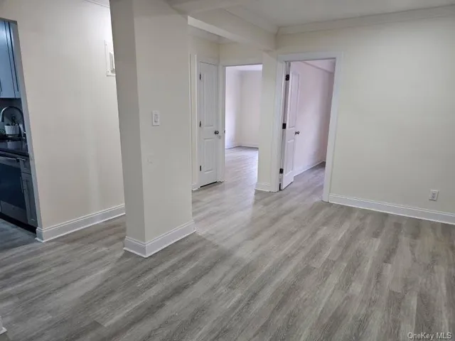 an empty room with wooden floor and a bathroom