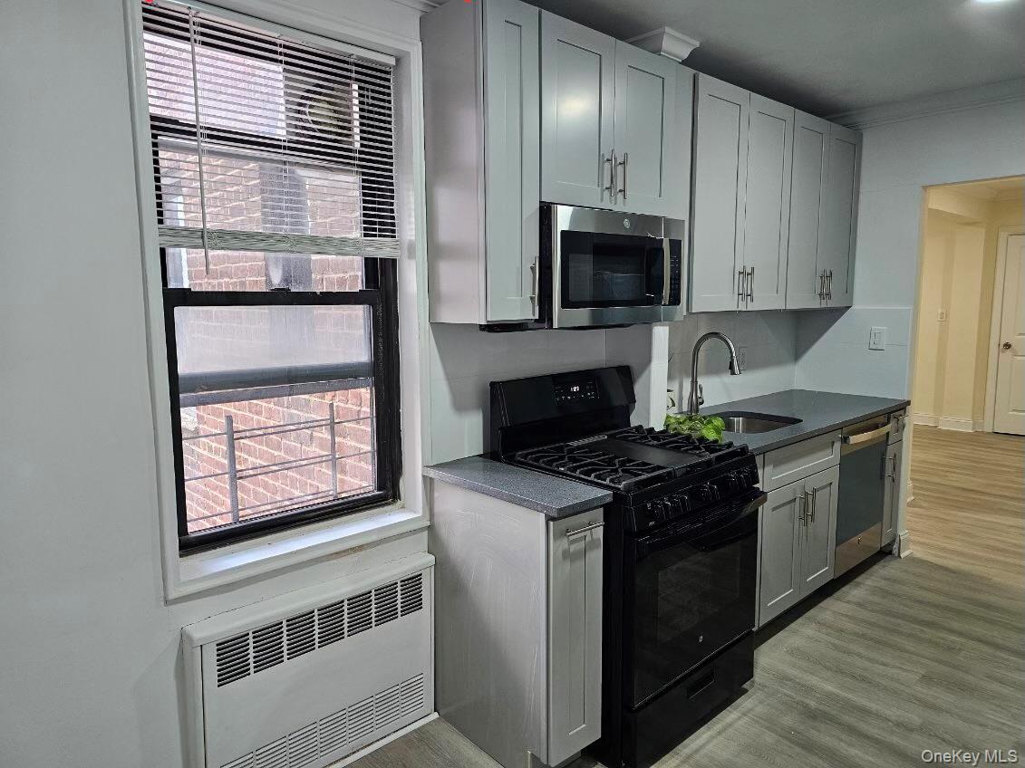 150-11 72nd Road, Unit 4D Queens, NY 11367 - Photo 3 of 13 a kitchen with stainless steel appliances granite countertop a stove a sink and a microwave