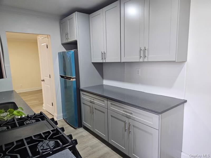 150-11 72nd Road, Unit 4D Queens, NY 11367 - Photo 6 of 13 a kitchen with white cabinets and refrigerator