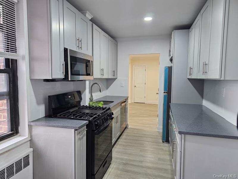 150-11 72nd Road, Unit 4D Queens, NY 11367 - Photo 7 of 13 a kitchen with stainless steel appliances granite countertop a stove a sink and a refrigerator