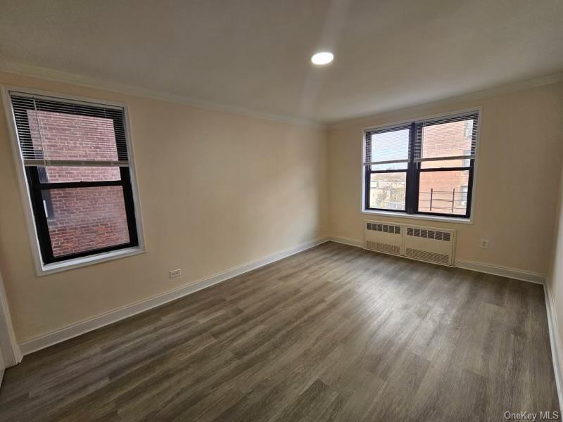 150-11 72nd Road, Unit 4D Queens, NY 11367 - Photo 8 of 13 a view of an empty room with wooden floor and a window
