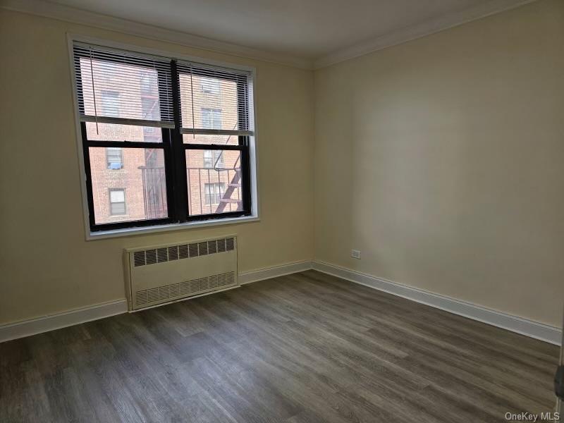 150-11 72nd Road, Unit 4D Queens, NY 11367 - Photo 9 of 13 an empty room with wooden floor and windows