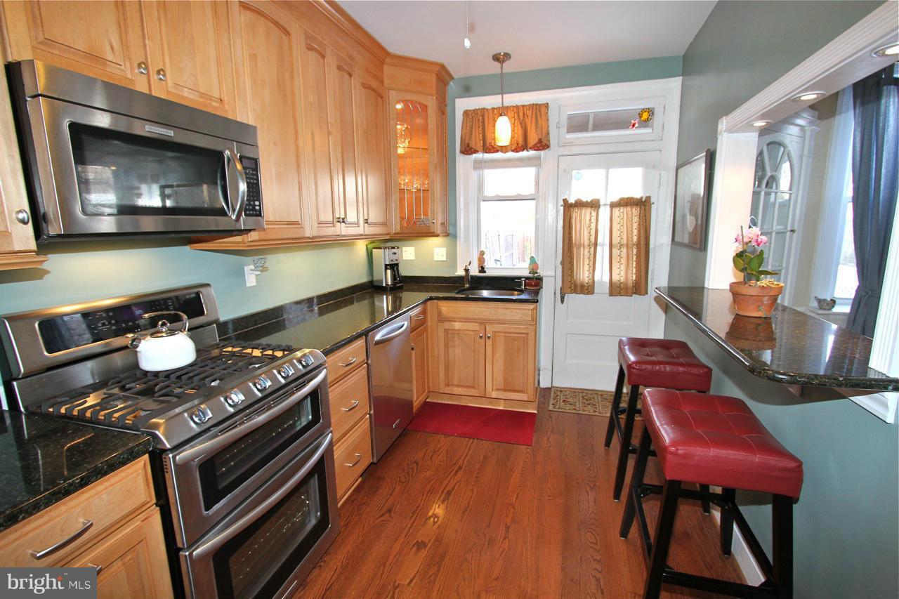 404 Hopkins Road Baltimore, MD 21212 - Photo 7 of 18 a kitchen with stainless steel appliances granite countertop a stove a sink and a microwave