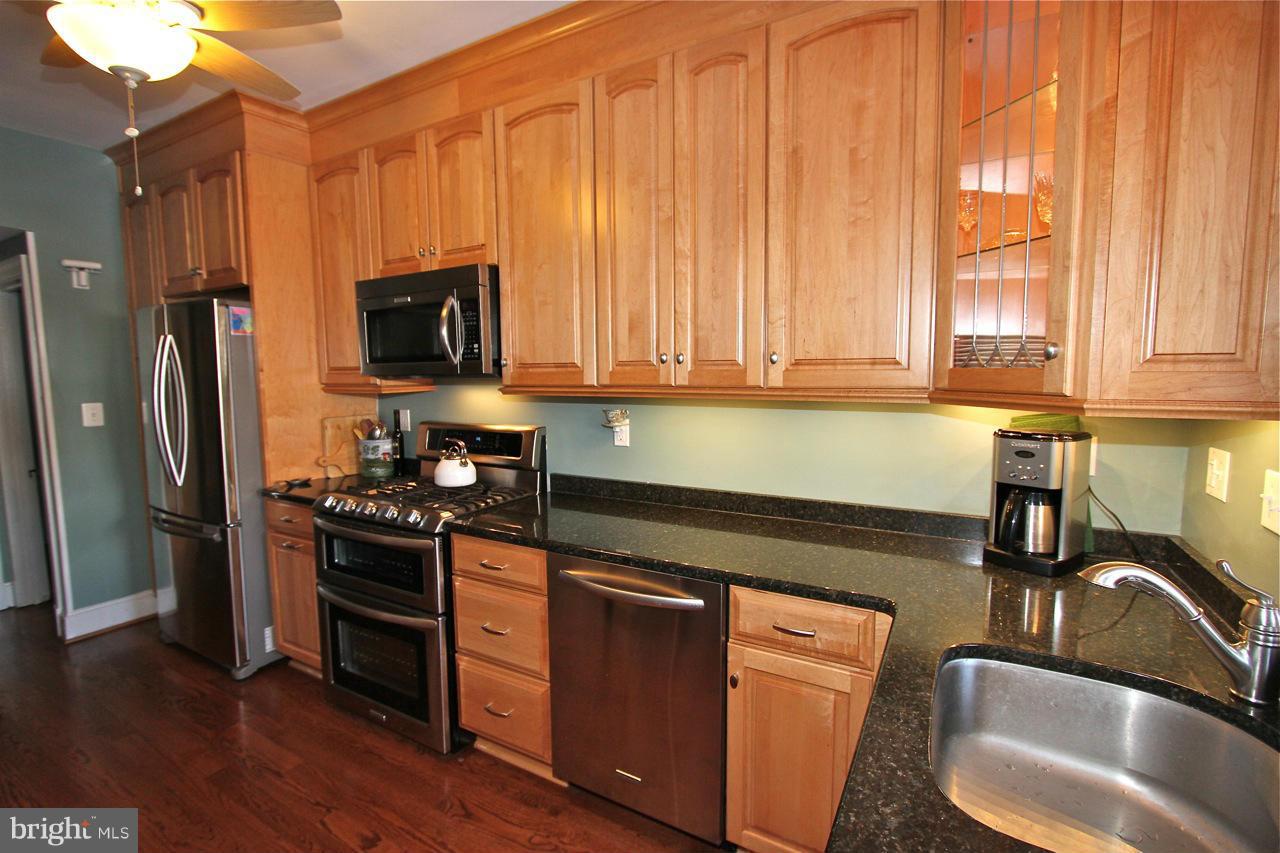 404 Hopkins Road Baltimore, MD 21212 - Photo 8 of 18 a kitchen with stainless steel appliances a sink a stove a microwave and wooden floors