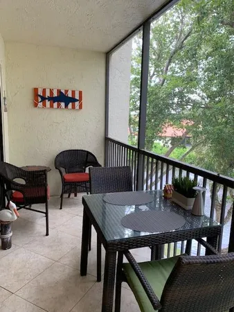 a view of a balcony with chairs and wooden floor