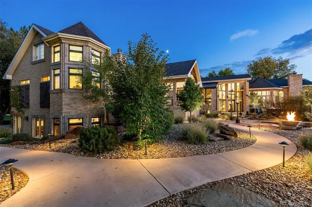 a view of a brick house with many windows next to a road