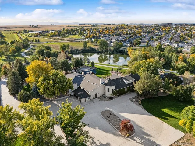 an aerial view of a house with a garden and lake view