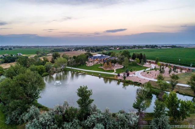 an aerial view of residential houses with outdoor space and lake view