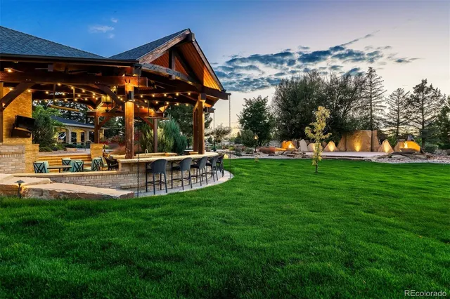a view of a swimming pool with lawn chairs and a big yard