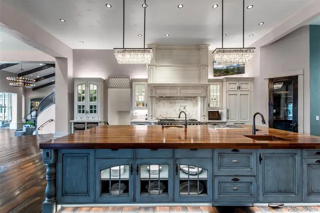a kitchen with kitchen island granite countertop wooden cabinets and a chandelier