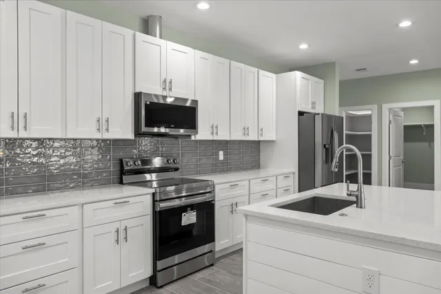 a kitchen with granite countertop white cabinets and white appliances