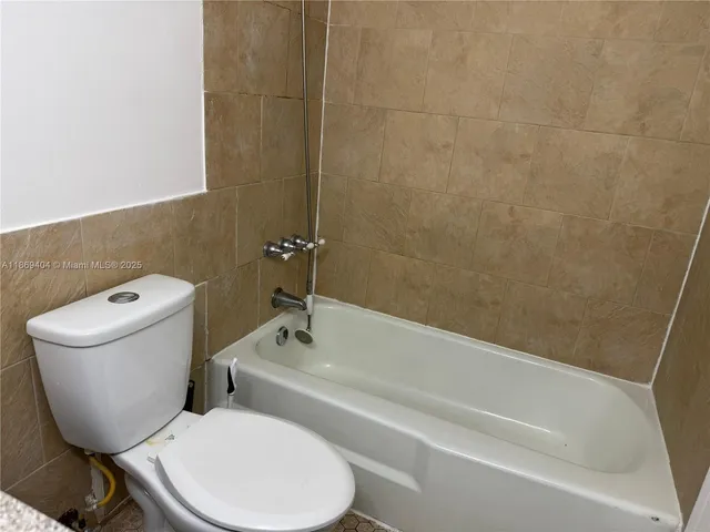 a white toilet sitting next to a bath tub