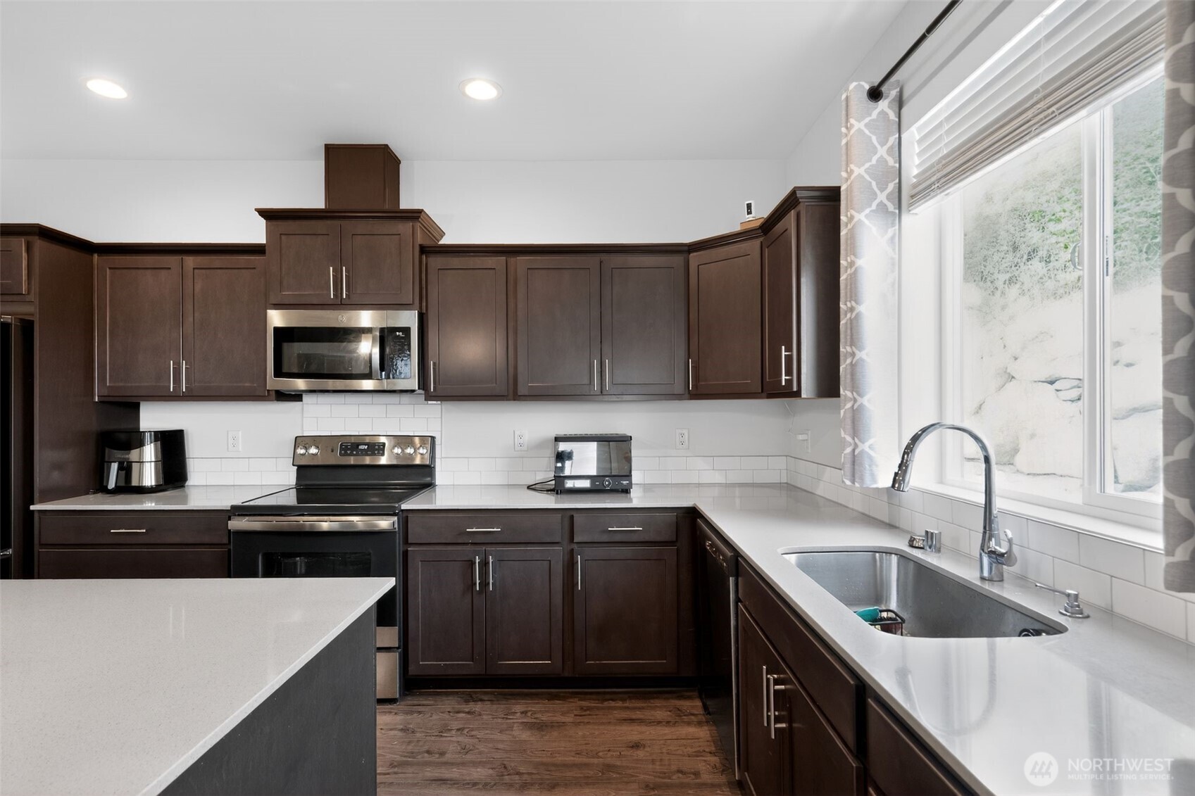 2134 Riverstone Loop Ferndale, WA 98248 - Photo 8 of 35 a kitchen with granite countertop a sink stainless steel appliances and cabinets