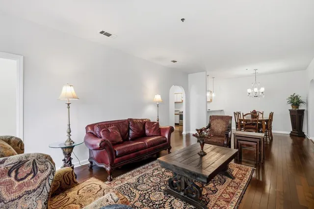 a living room with furniture a rug and a lamp