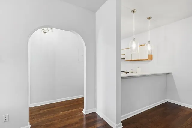 a view of a room with wooden floor and white walls