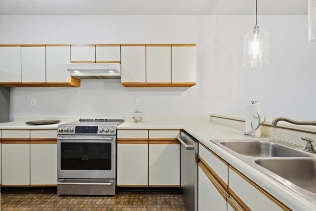 a kitchen with white cabinets and white appliances