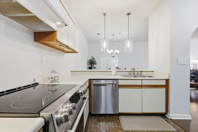 a kitchen with kitchen island granite countertop a sink a counter space appliances and cabinets