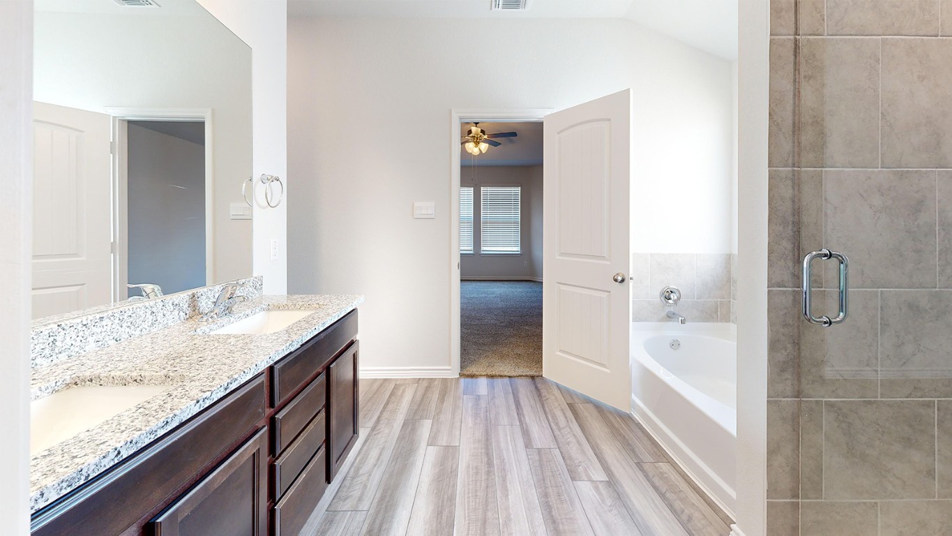 305 Creekfall Road Burnet, TX 78611 - Photo 16 of 33 a bathroom with a granite countertop sink a toilet and shower