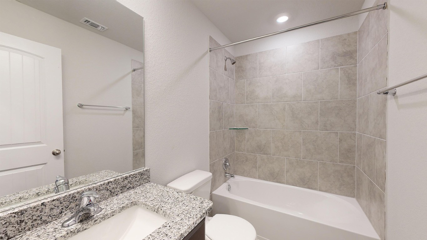 305 Creekfall Road Burnet, TX 78611 - Photo 26 of 33 a bathroom with a granite countertop bathtub shower sink and toilet