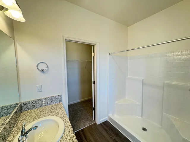 a bathroom with a granite countertop sink toilet and shower
