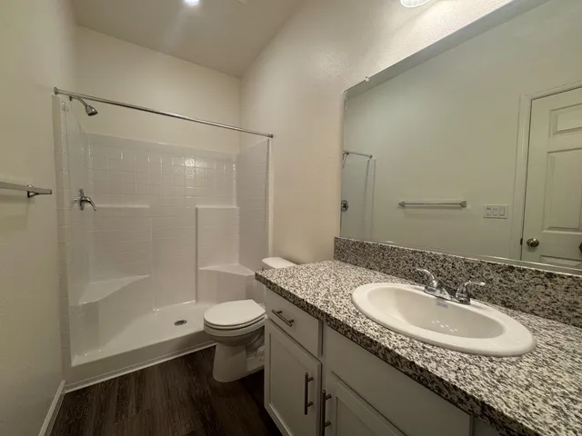 a bathroom with a sink a toilet and shower