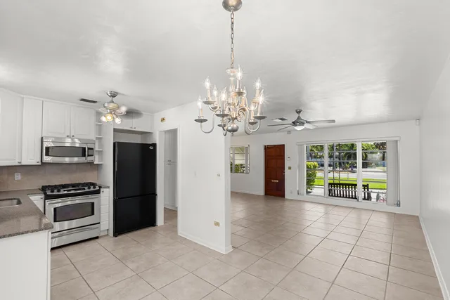 a kitchen with stainless steel appliances kitchen island granite countertop a refrigerator and a stove top oven