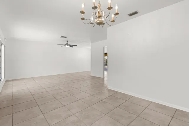 an empty room with a chandelier fan