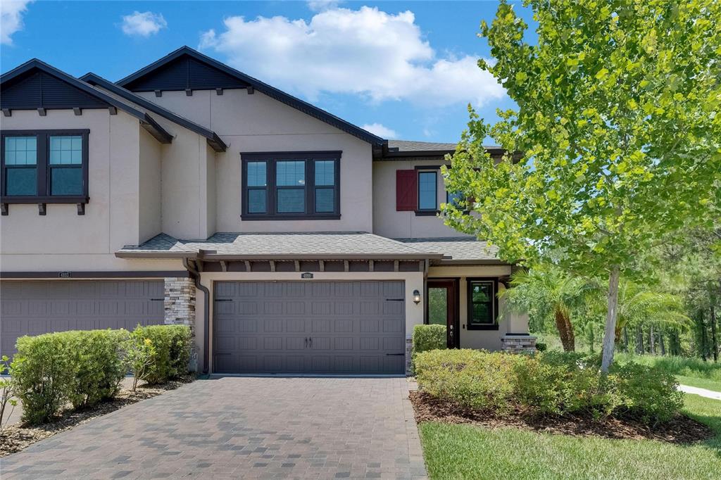 4899 Isola Court Wesley Chapel, FL 33543 - Photo 19 of 86 a front view of a house with a garden and plants