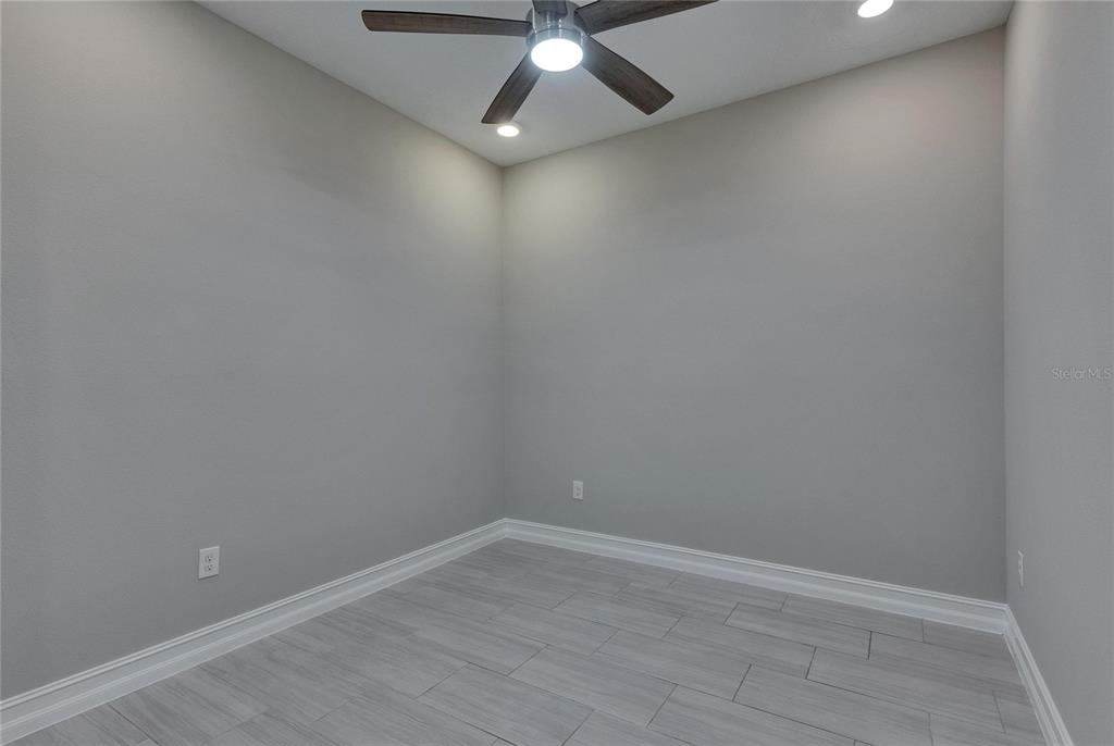4899 Isola Court Wesley Chapel, FL 33543 - Photo 24 of 86 en empty room with wooden floor and ceiling fan