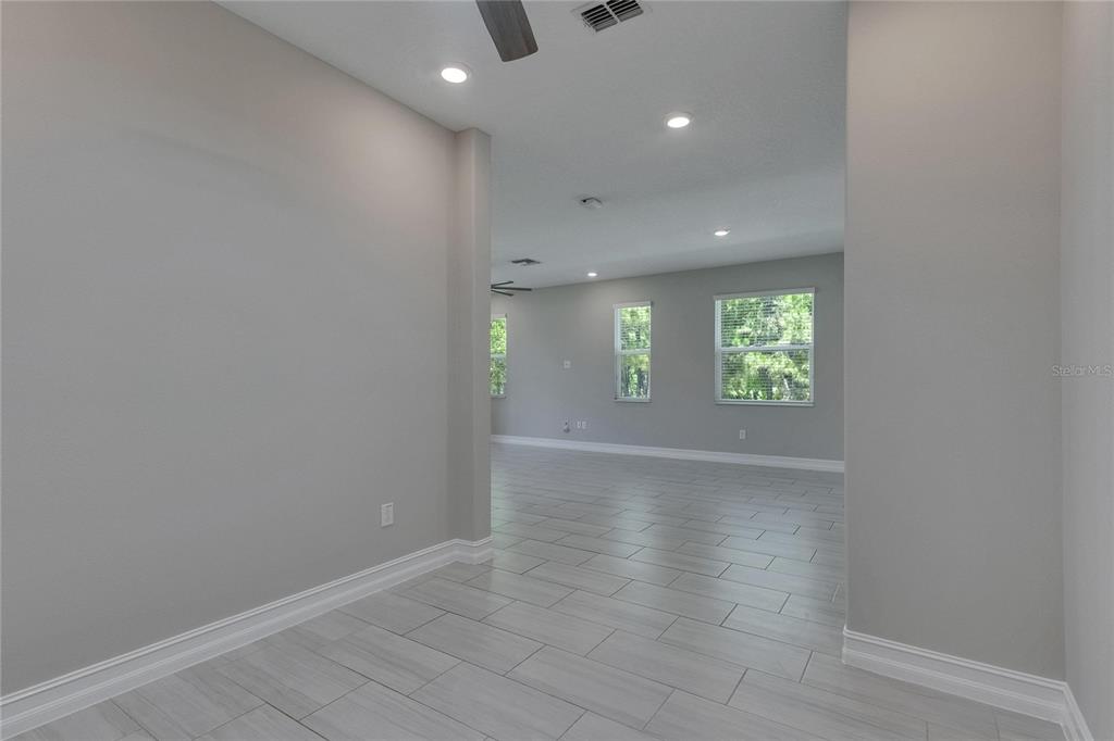 4899 Isola Court Wesley Chapel, FL 33543 - Photo 25 of 86 an empty room with windows and entrance