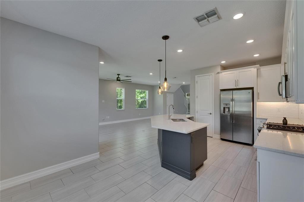 4899 Isola Court Wesley Chapel, FL 33543 - Photo 28 of 86 a large kitchen with a large counter top stainless steel appliances and cabinets