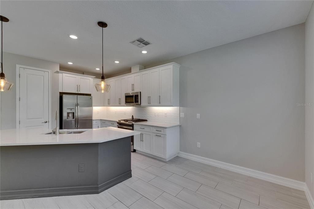 4899 Isola Court Wesley Chapel, FL 33543 - Photo 30 of 86 a large kitchen with a large counter top appliances and cabinets