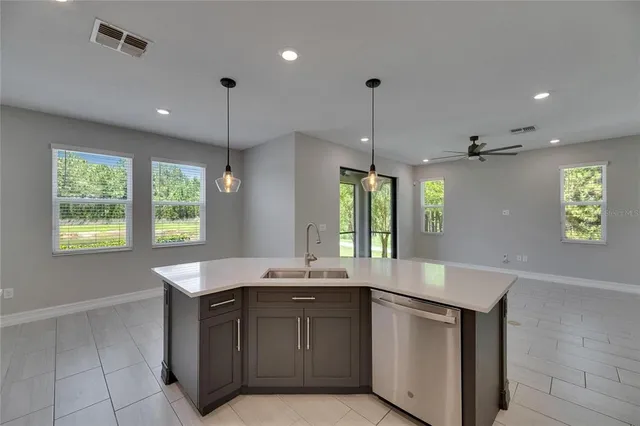 an empty room with wooden floor and a ceiling fan