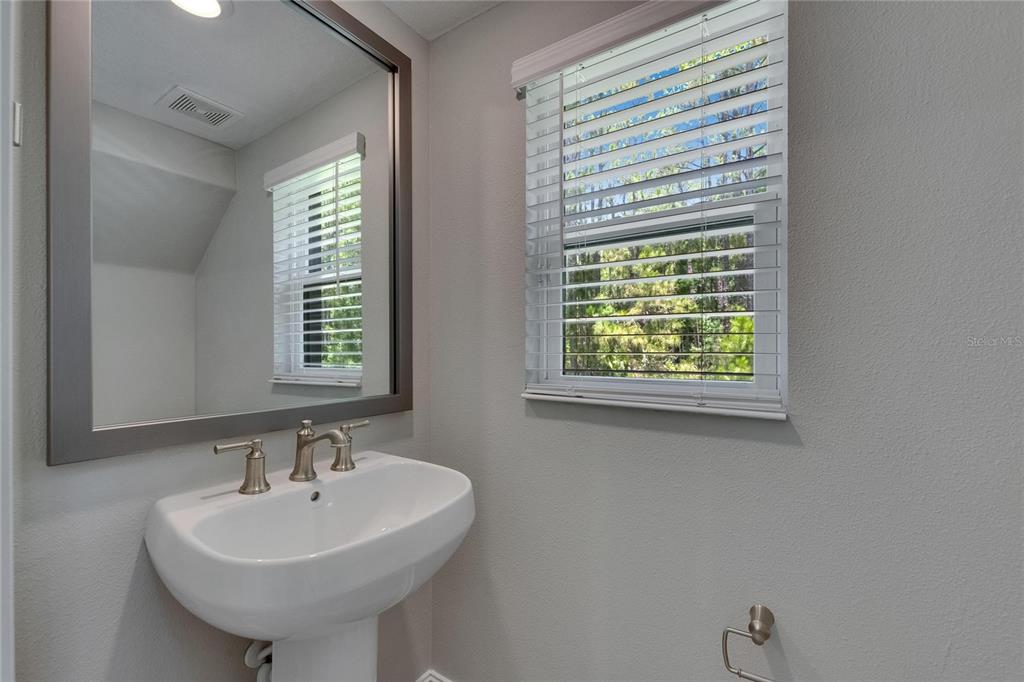 4899 Isola Court Wesley Chapel, FL 33543 - Photo 42 of 86 a bathroom with a sink a mirror and a window